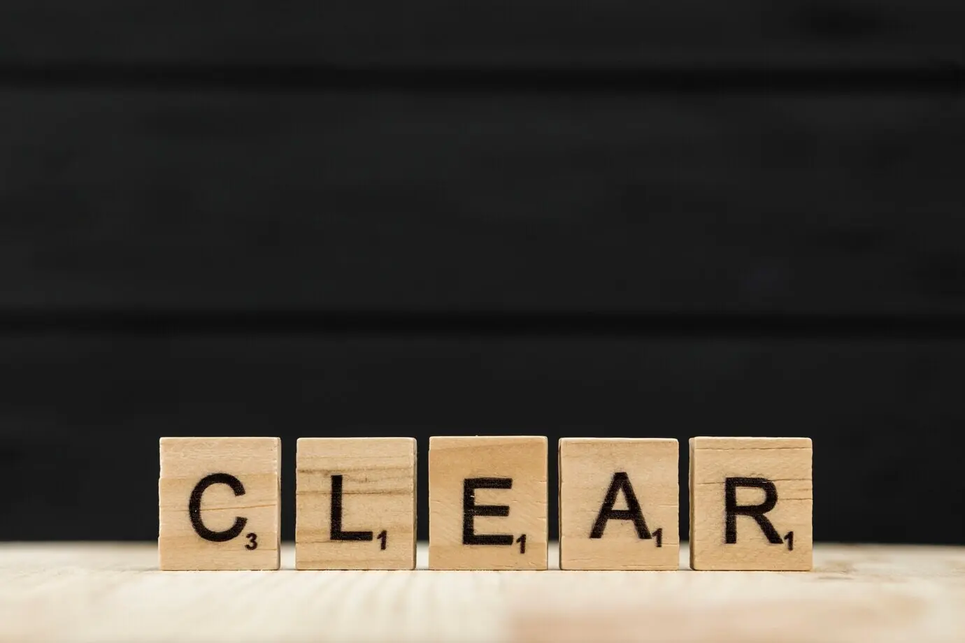 Das Wort „clear“ mit Holzbuchstaben buchstabiert.